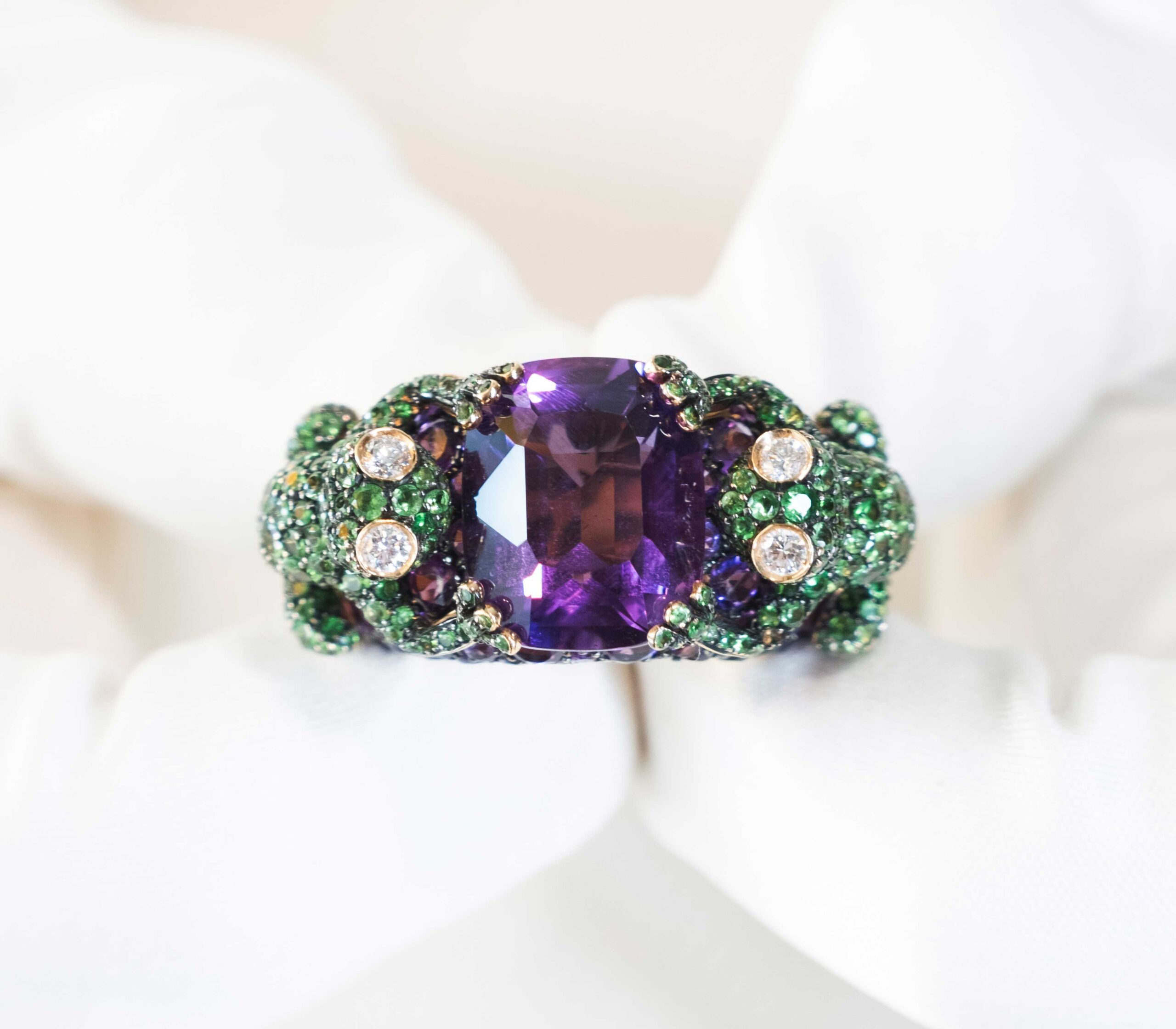 De Grisogono Frog Ring with Amethyst, Tsavorites, and Diamonds in the hands.