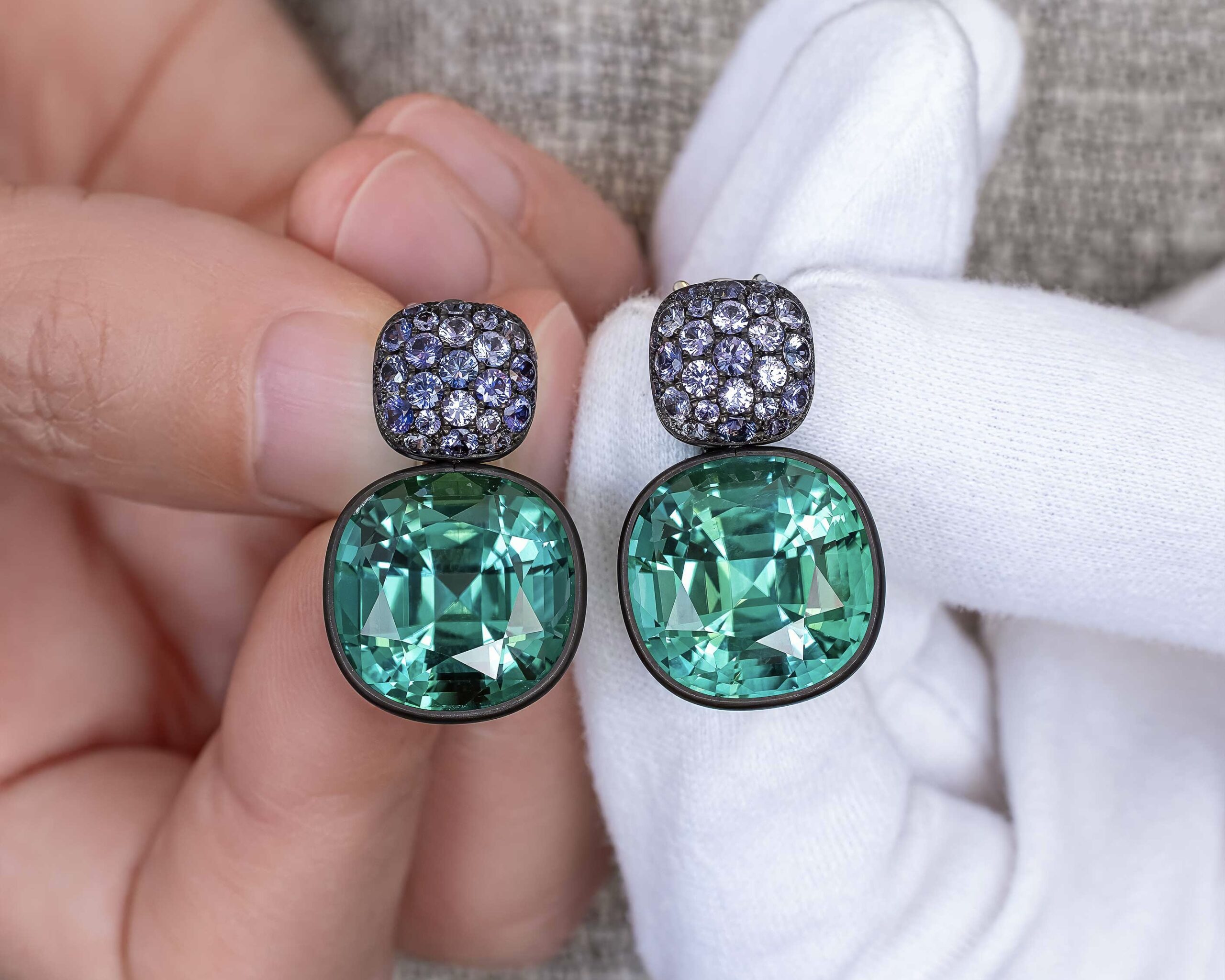 One-of-a-Kind Tourmaline and Sapphire Earrings in the hands.